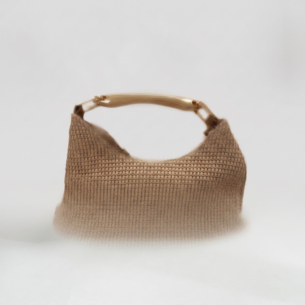 Bolso tono natural sobre fondo gris de estudio