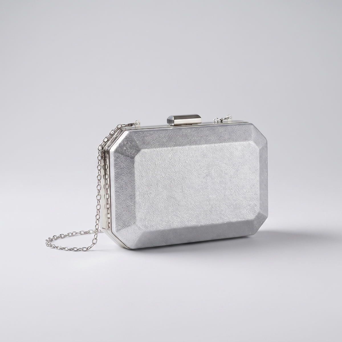 Clutch plateado sobre fondo gris de estudio