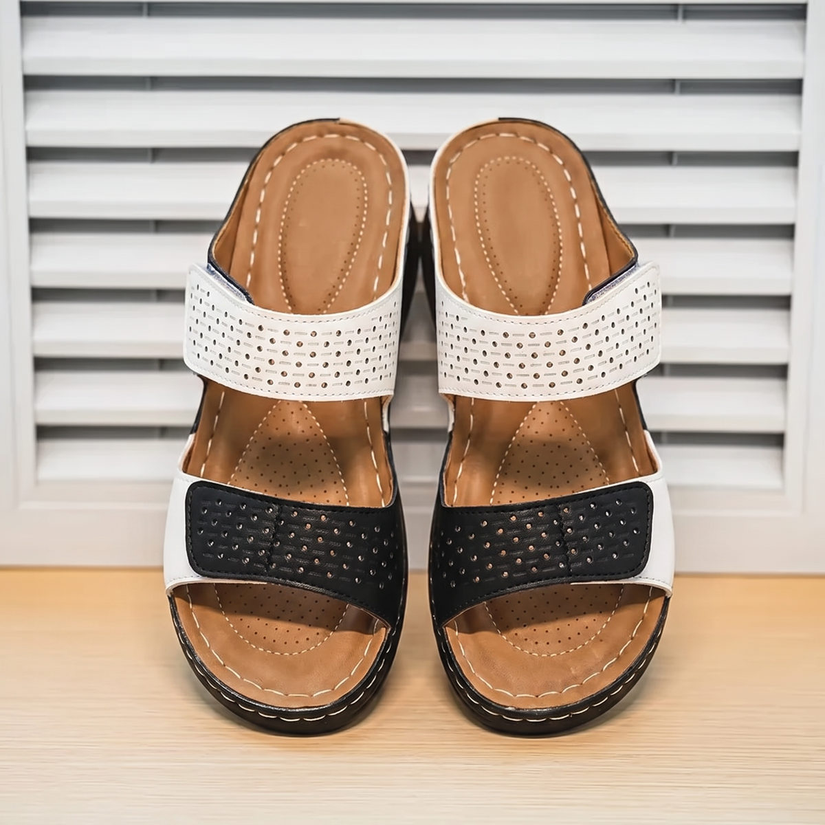 Sandalias Ortopédicas Elegantes sobre fondo de persiana blanca