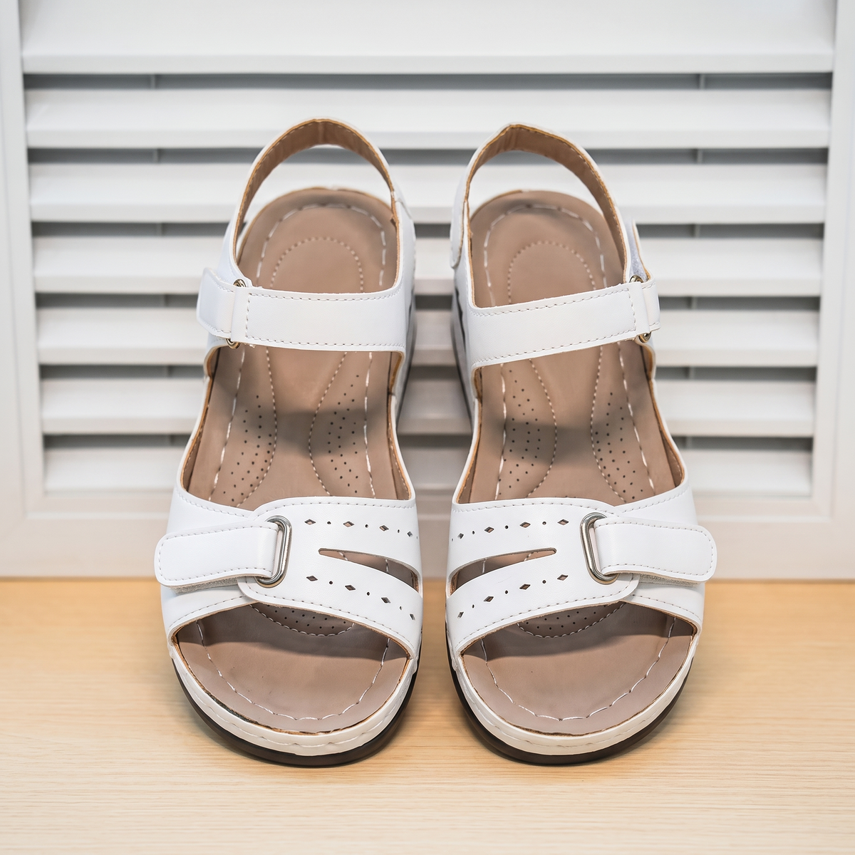 Sandalias Ortopédicas de Confort Flex sobre fondo de persiana blanca