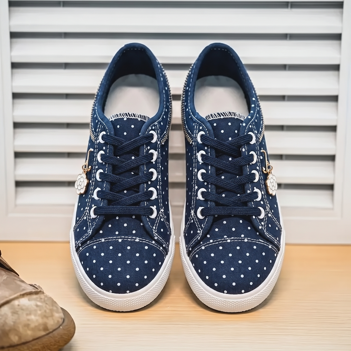 Zapatillas Elegantes con Detalles Florales sobre fondo de persiana blanca