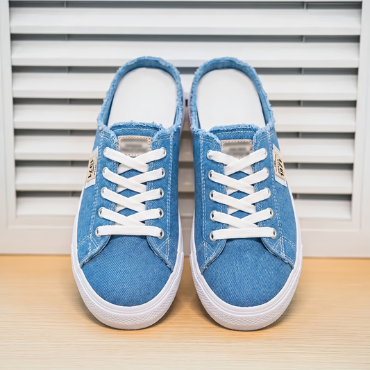 Zapatillas Mule Denim Premium sobre fondo de persiana blanca